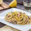 Spaghetti con tonno e limone in una padella con prezzemolo fresco
