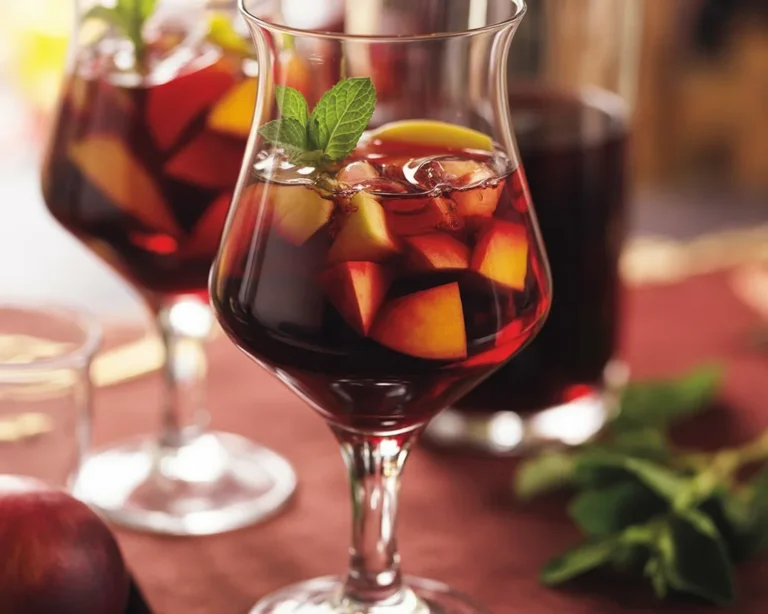 Una brocca di sangria con frutta fresca e vino rosso, ideale per l'estate.