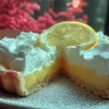 Torta al limone con crema di mascarpone decorata con limoni freschi.