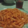Piatto di mezze penne al baffo con salsa cremosa e ingredienti freschi