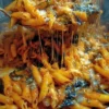 Pasta con melanzane fritte e provolone affumicato servita in un piatto