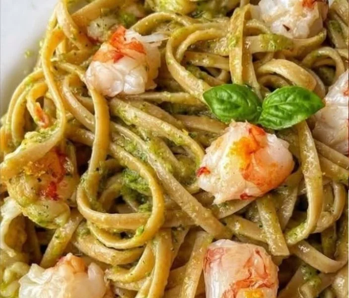 Linguine con pesto di zucchine e gamberi in un piatto colorato