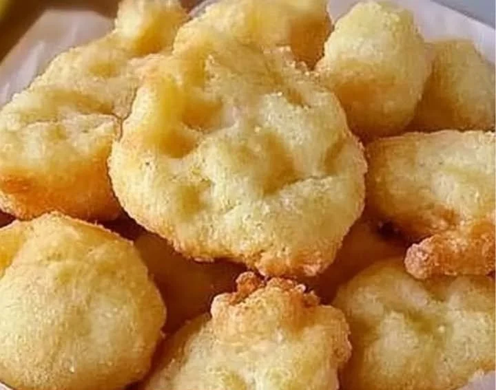 Zeppole di pasta cresciuta fresche appena fritte e spolverate di zucchero a velo.