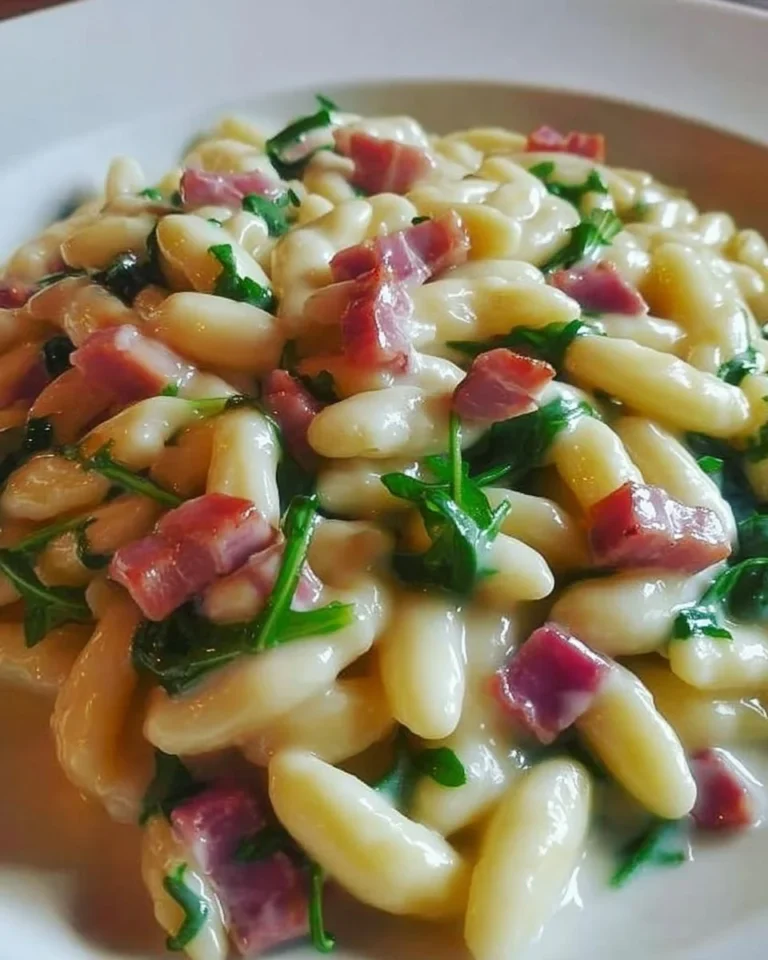 Cavatelli freschi con speck, rucola e crema di patate serviti in un piatto