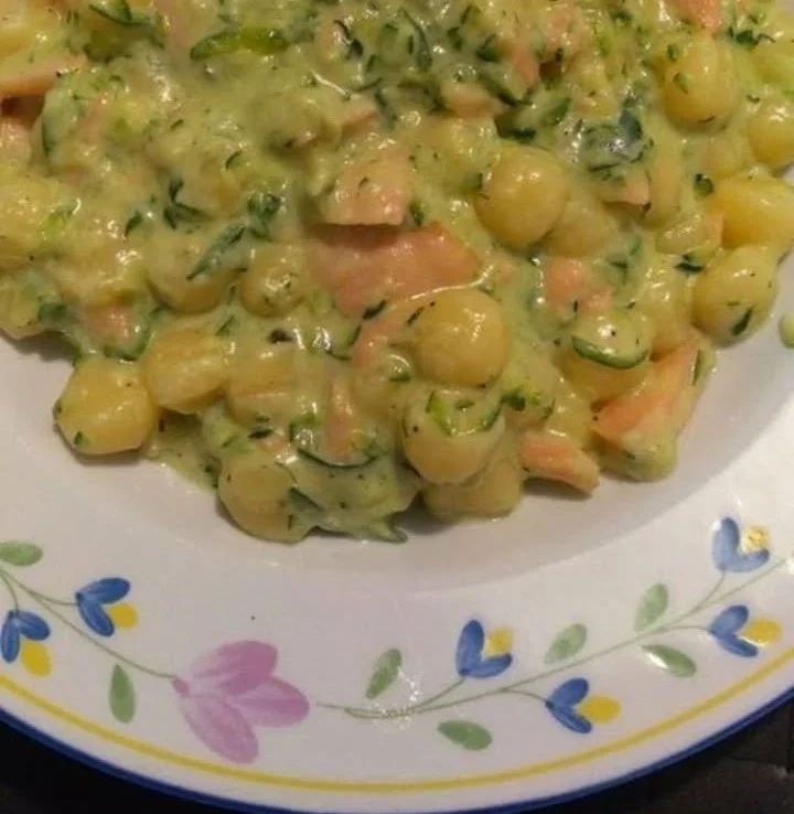 Piatto di gnocchetti zucchine e salmone affumicato con ingredienti freschi.