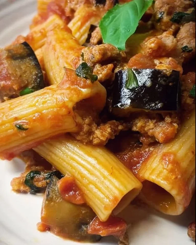 Paccheri con melanzane e salsiccia serviti su un piatto elegante