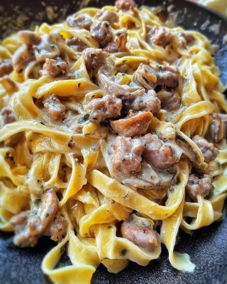 Tagliatelle con funghi porcini e salsiccia servite in un piatto elegante