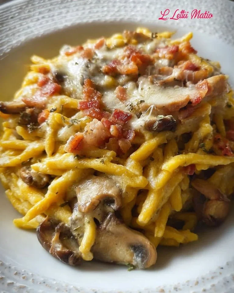 Trofie allo zafferano con funghi, provola e pancetta in un piatto gourmet.