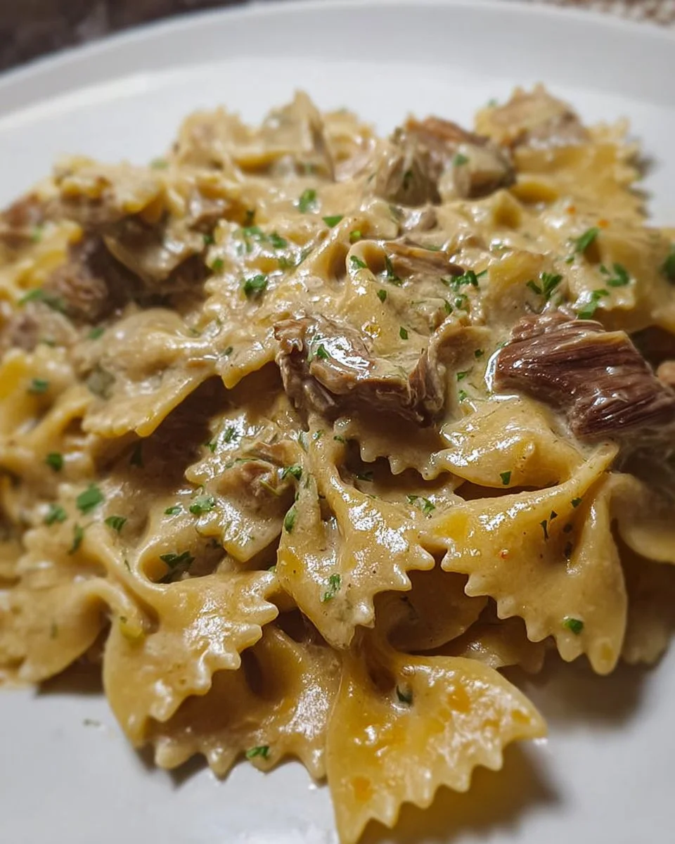 Farfalle con crema di carciofi e cuori saltati in un piatto gourmet.