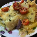 Baccalà al forno con patate, pomodorini e olive servito su un piatto
