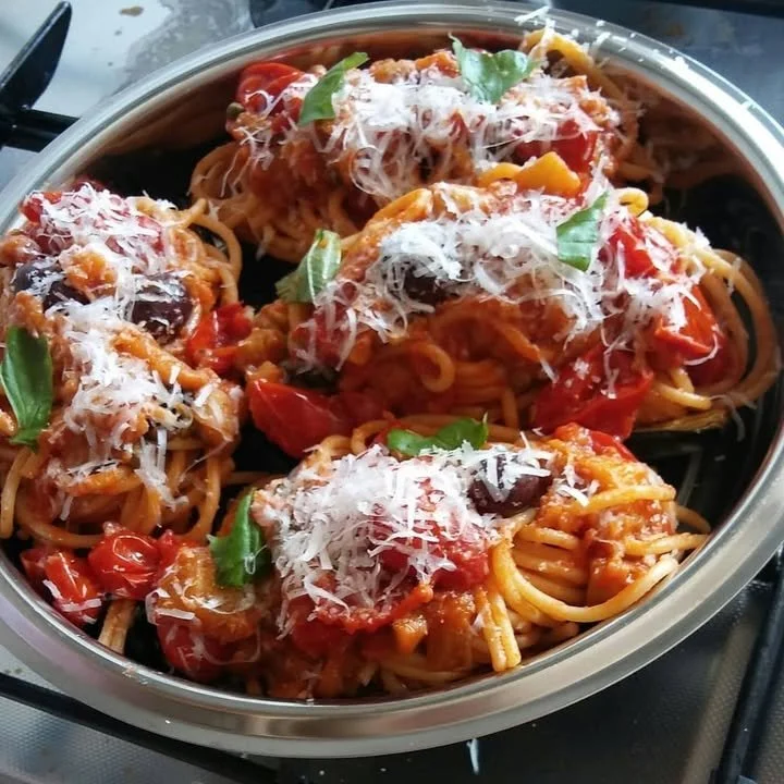 Barchette di melanzane ripiene di bucatini alla siciliana su un piatto.