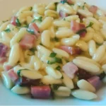 Cavatelli freschi con speck, rucola e crema di patate serviti nel piatto