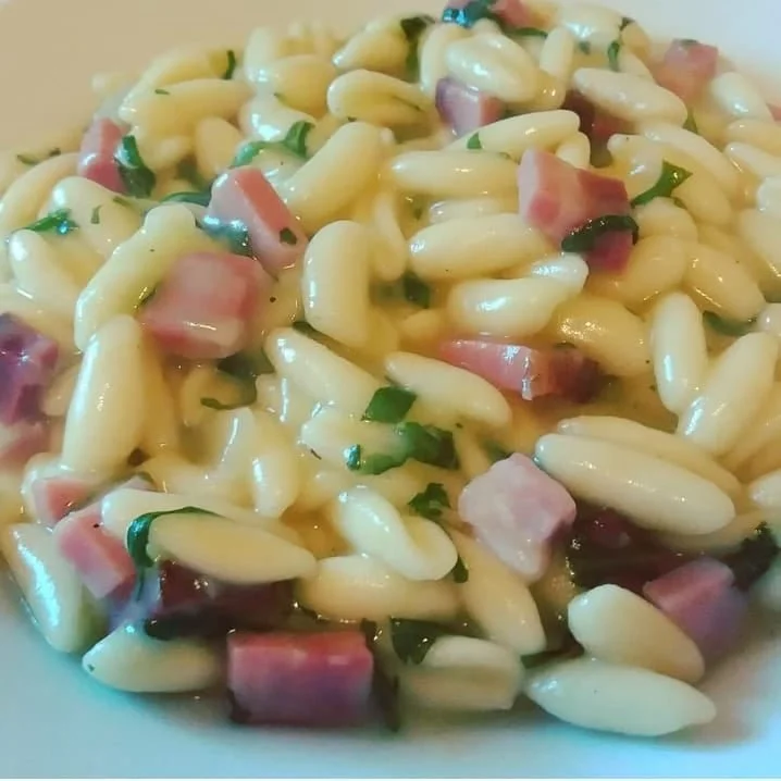 Cavatelli freschi con speck, rucola e crema di patate serviti nel piatto