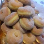 Ciambelle fresche e soffici con zucchero a velo, pronte per essere gustate.