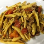 Cortecce con salsiccia, funghi e pomodorini servite in un piatto