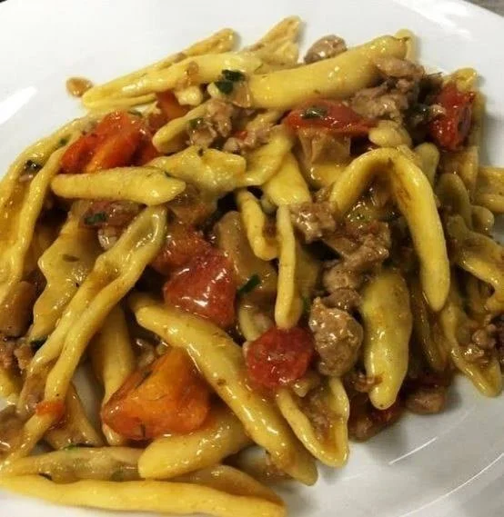 Cortecce con salsiccia, funghi e pomodorini servite in un piatto