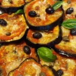 Fettine di melanzane alla pizzaiola servite su un piatto