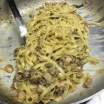 Piatto di fettuccine con funghi porcini e salsiccia, ricetta italiana