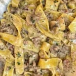 Fettuccine con funghi porcini e salsiccia serviti in un piatto elegante.