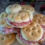 Focaccine morbide appena sfornate su un piatto, pronte in poche ore.