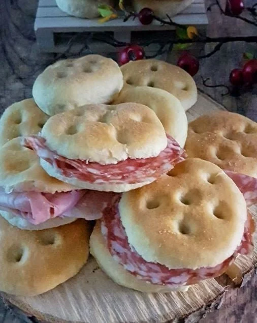 Focaccine morbide appena sfornate su un piatto, pronte in poche ore.