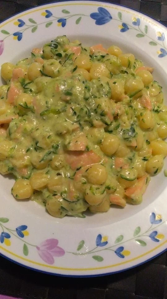 Gnocchetti zucchine e salmone affumicato serviti in un piatto