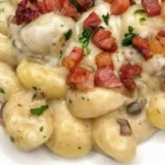 Gnocchi con crema al parmigiano, funghi e speck in un piatto appetitoso