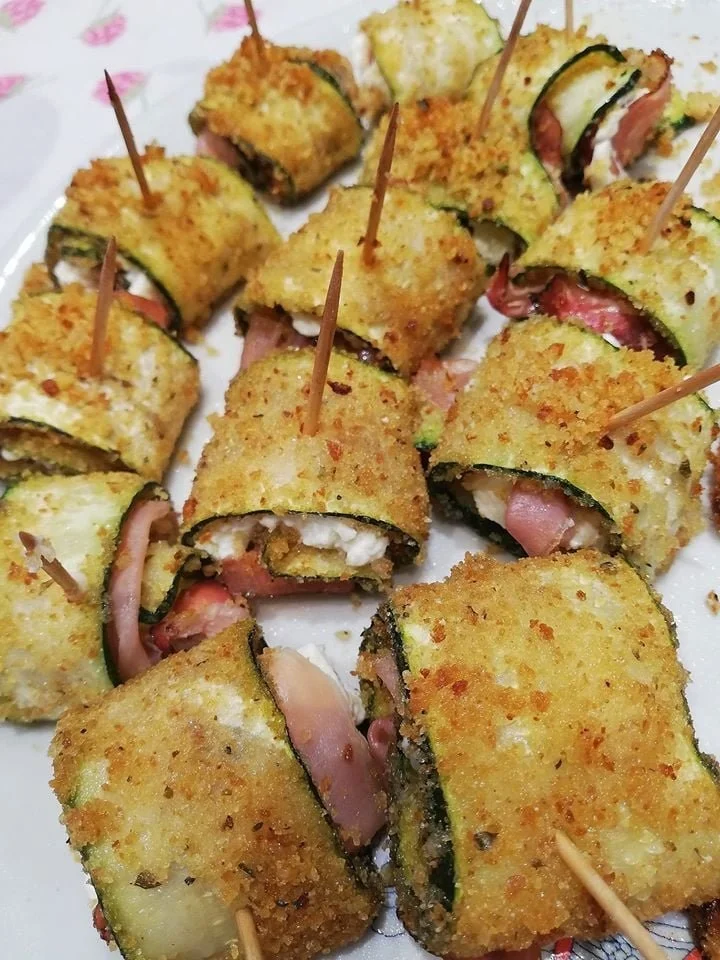 Involtini di zucchine ripieni e guarniti, piatto estivo sano e delizioso.