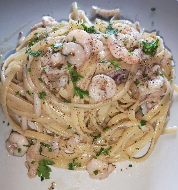 Piatto di linguine calamaro e gamberetto con ingredienti freschi