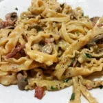 Mafaldine con crema di funghi e pancetta, piatto italiano ricco e saporito.