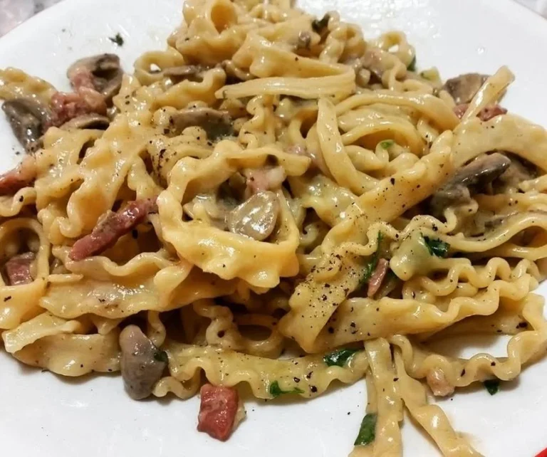 Mafaldine con crema di funghi e pancetta, piatto italiano ricco e saporito.