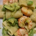 Mezzi paccheri con gamberi e zucchine in un piatto colorato