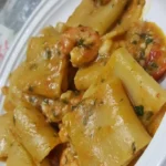 Paccheri con scampi e gamberi serviti su un piatto elegante