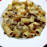 Pasta con crema di patate e salsiccia servita in un piatto gustoso