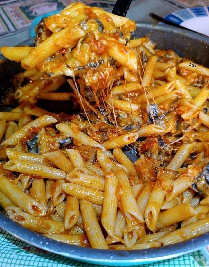 Pasta con Melanzane Fritte e Provola Affumicata servita in un piatto elegante