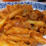 Pasta con melanzane fritte e provola affumicata in un piatto appetitoso