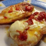 Petti di pollo alla pizzaiola con pomodorini e mozzarella su un piatto