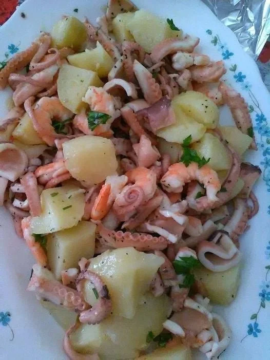 Polpo all'insalata con gamberetti e patate su un piatto elegante