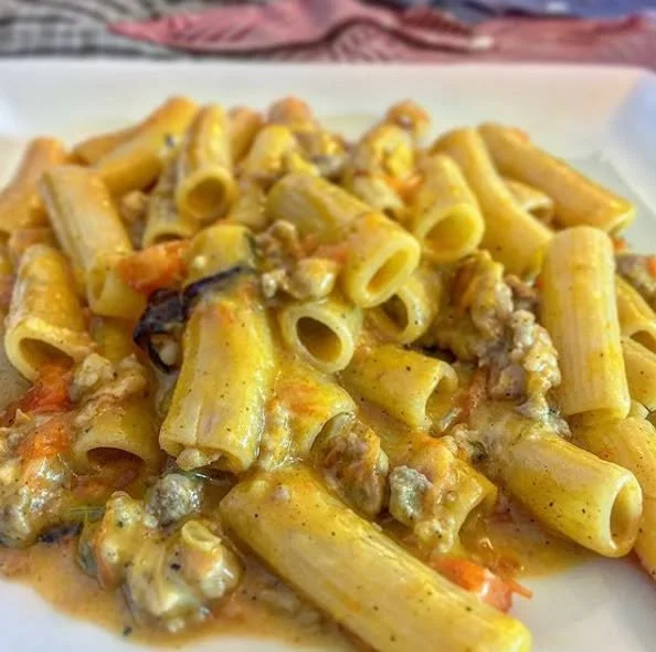 Piatto di rigatoni zucca, salsiccia e provola con decorazione