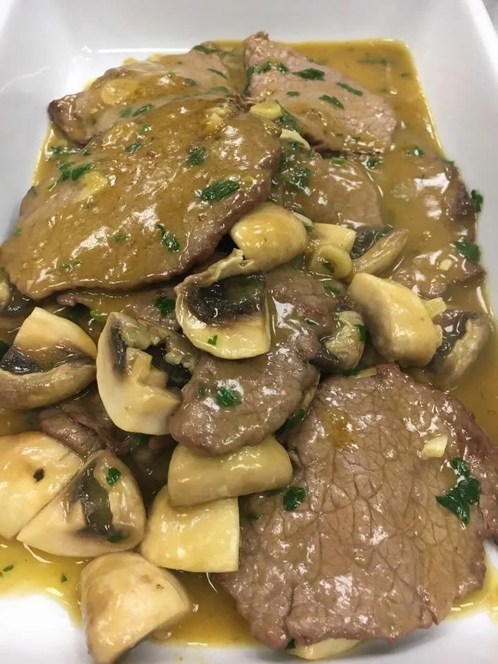 Scaloppine con demi-glacé di funghi servite su un piatto gourmet