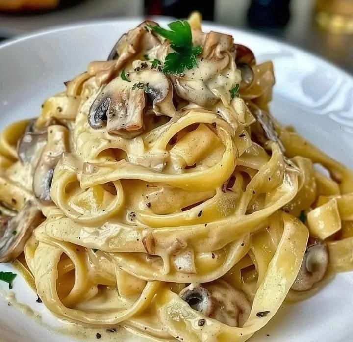 Tagliatelle con crema di parmigiano e funghi porcini in un piatto gourmet