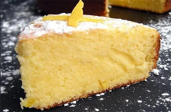 Fetta di torta al limone decorata con limoni freschi
