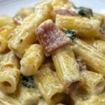 Pasta Tortiglioni con Zucchine, Pancetta e Crema di Parmigiano servita in un piatto