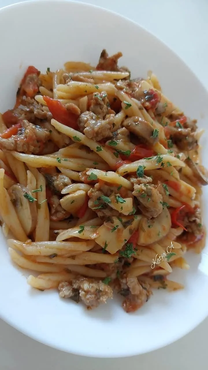 Trofie con Salsiccia e Funghi servite in un piatto