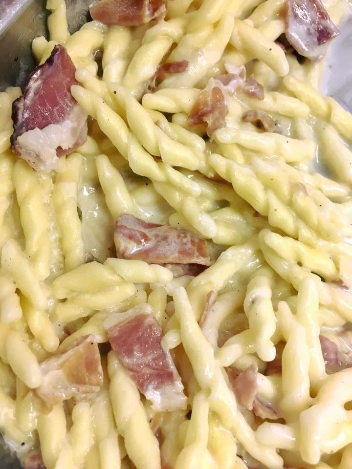 Piatto di Trofie con Speck e Provola servito su un tavolo