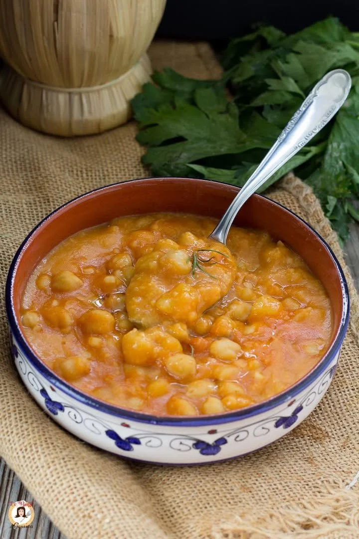 Ciotola di zuppa di ceci e patate fumante con erbe fresche