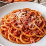 Piatto di bucatini alla marchigiana servito con salsa ricca e saporita.