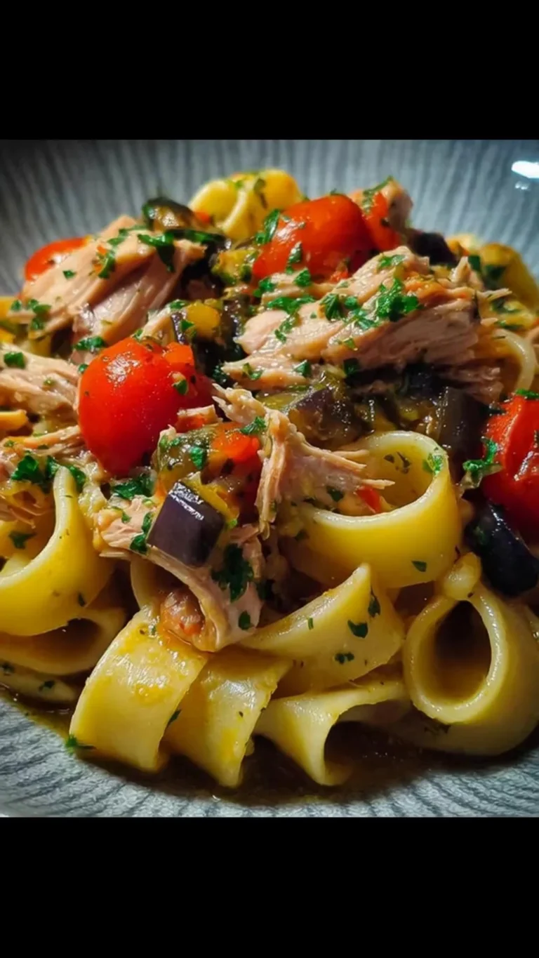 Calamarata con tonno fresco, melanzane e pomodorini in un piatto delizioso.