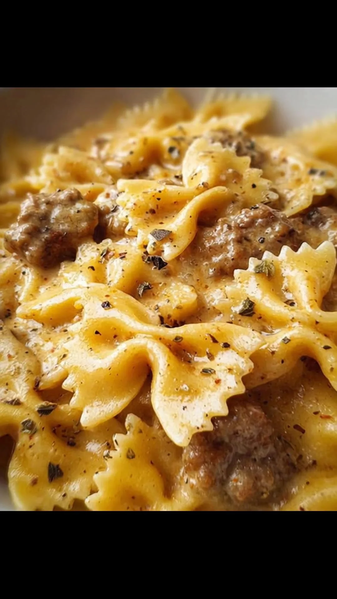 Farfalle con Salsiccia, Panna e Zafferano servite in un piatto elegante