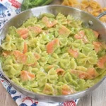Farfalle con crema di zucchine e salmone, un piatto gourmet colorato e gustoso.